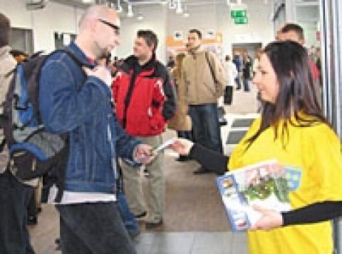 Żaneta Grabowska, stażystka Urzędu Miejskiego, rozdaje pasażerom przylatującym z Londynu folder o Pabianicach
