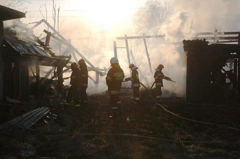Pożar wybuchł w niedzielę po godzinie 17.30 w drewnianej stodole. Ogień szybko się rozprzestrzenił na pobliskie budynki gospodarcze. Na miejsce przyjechało 14 wozów strażackich. 