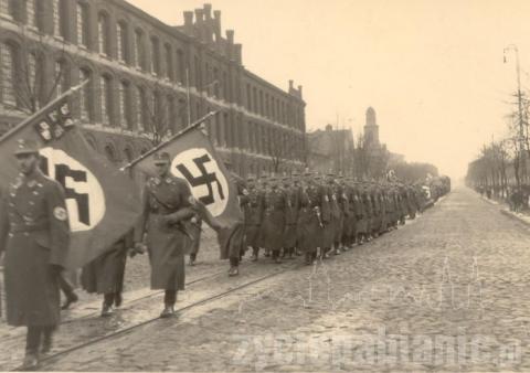 5 października 1939 roku. Faszystowski pochód kroczy ulicą Zamkową. Polacy muszą zdejmować przed nim czapki