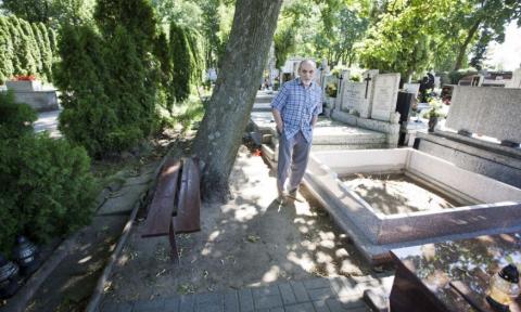 Pan Alojzy opiekuje się grobem na cmentarzu katolickim.