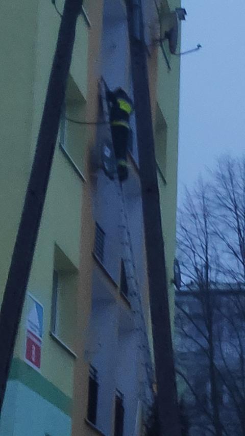 Strażak wspiął się po drabinie do okna na 3 piętrze