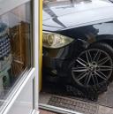 BMW zatrzymało się na chodniku, w drzwiach sklepu